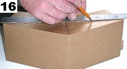 Lay on a table and draw a horizontal line across to mark off the excess cardboard on both sides.